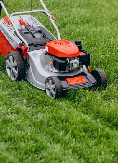 Man cutting grass with lawn mover in the back yard